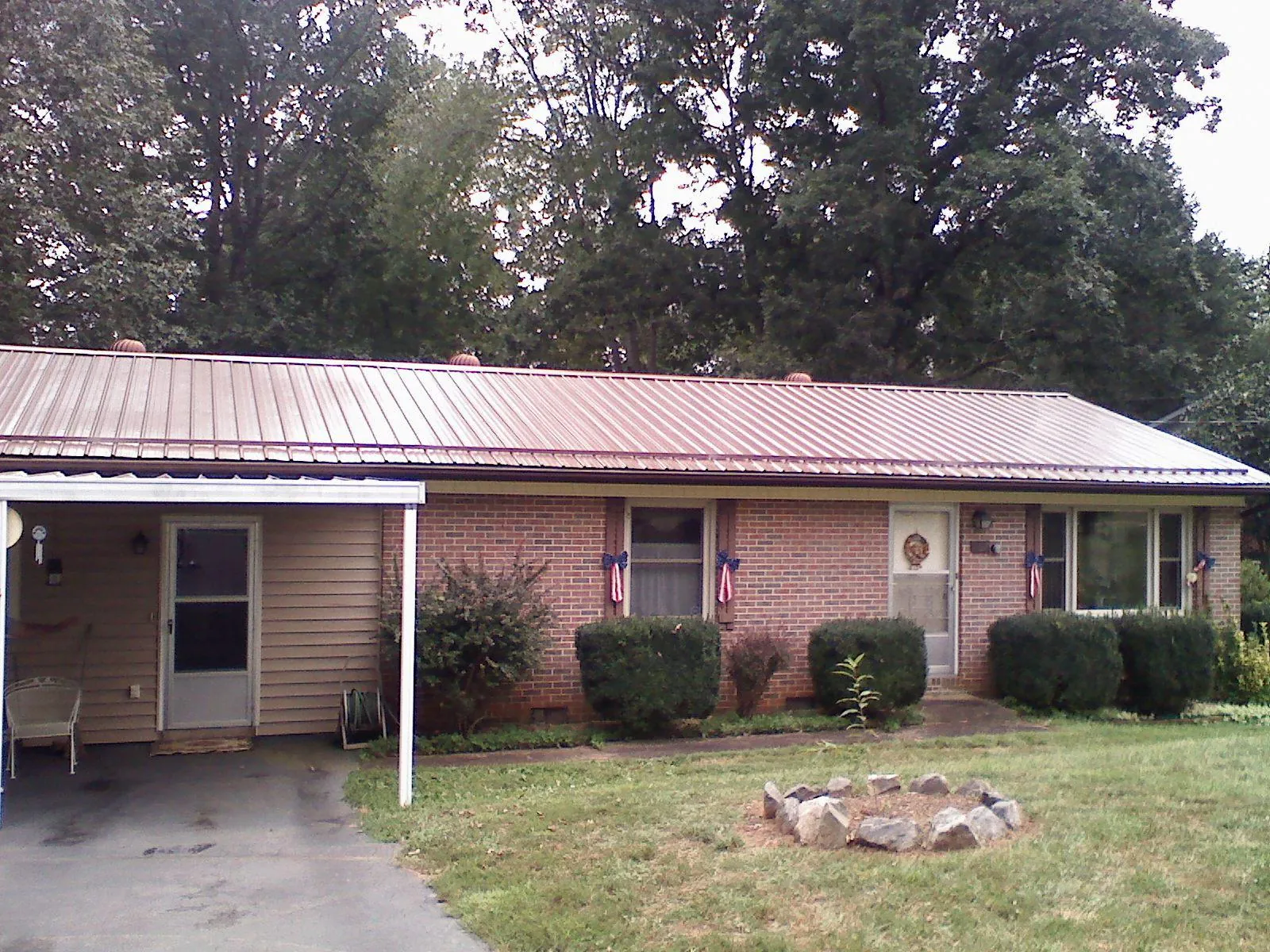 Bronze metal roof and carport on a brick ranch home — Roof Repair work by our crew in Stewartville